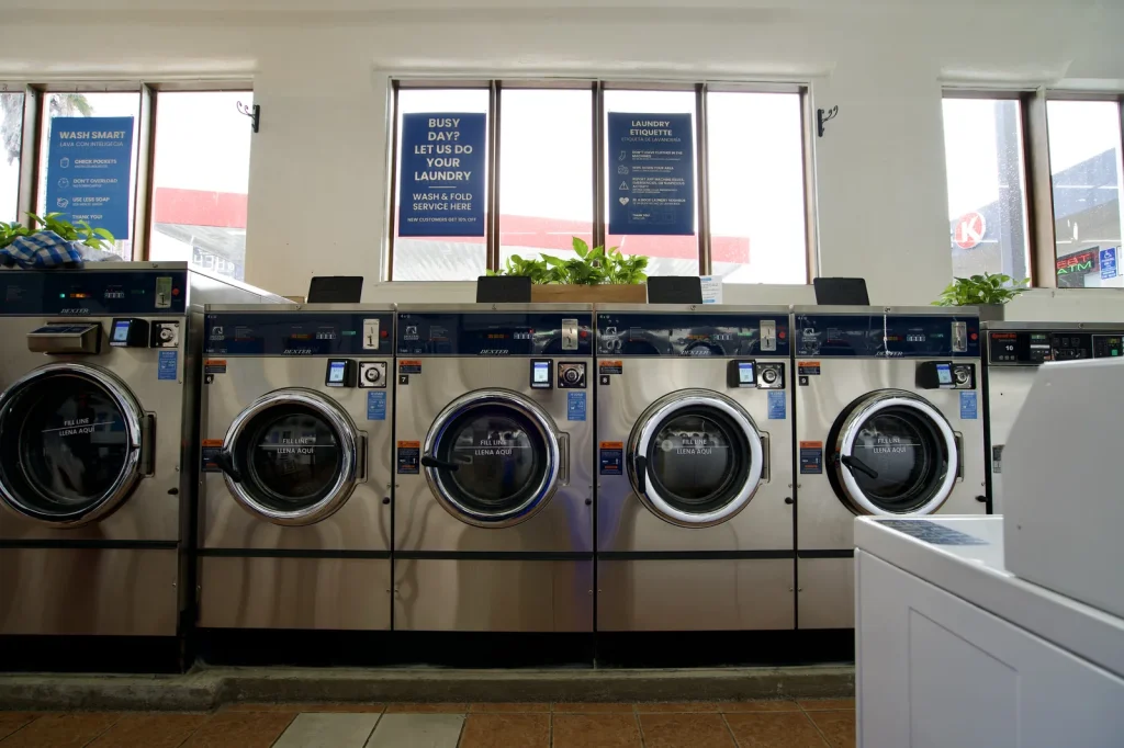 Washers below the front windows under the wash and fold service sign at The Laundry Hub SF